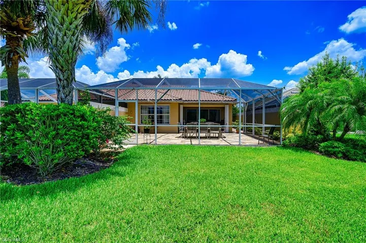 Rear view of property with a screened large Lanai with custom floor