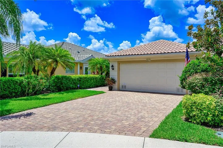 Mediterranean / Spanish-style house with a two-car garage and paver driveway