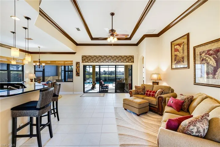Living area featuring a tray ceiling with crown molding, healthy amount of natural light