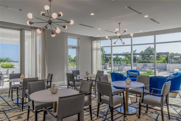 Social room features large open relaxed dining space with contemporary chandelier and recessed lighting.