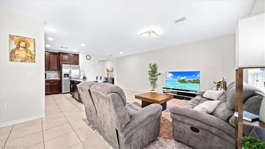 Living area with light tile patterned floors, arched walkways, and recessed lighting