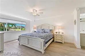 Bedroom featuring baseboards, wood finished floors, and ceiling fan