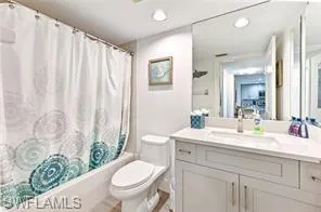 Bathroom featuring vanity, toilet, shower / tub combo, and recessed lighting