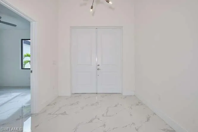 Entryway foyer with light marble finish flooring and baseboards