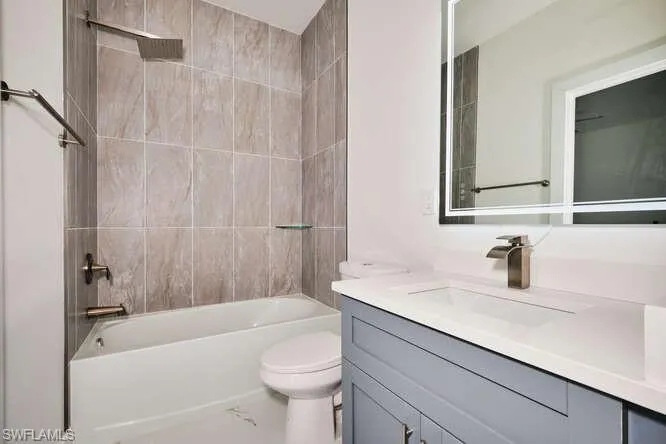 Full bathroom featuring vanity, bathing tub / shower combination, and marble finish floors