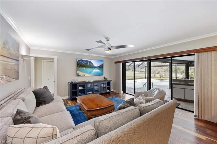 Family room with crown molding, wood floors, and new ceiling fan with access to pool