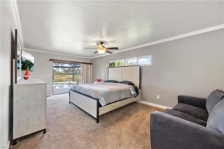 Carpeted bedroom featuring access to exterior, ornamental molding, and ceiling fan