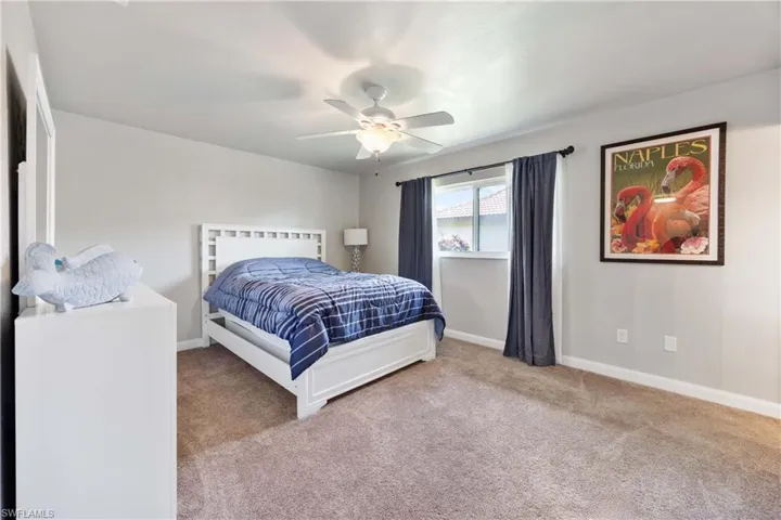 Bedroom 2 has neutral carpeting and ceiling fan