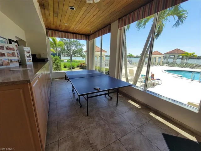 Game room with wooden ceiling and dark tile floors