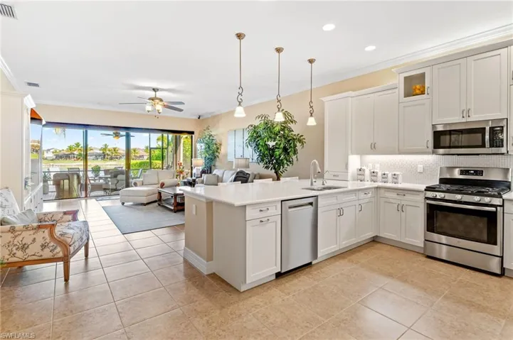 Kitchen features custom cabinetry and breakfast bar