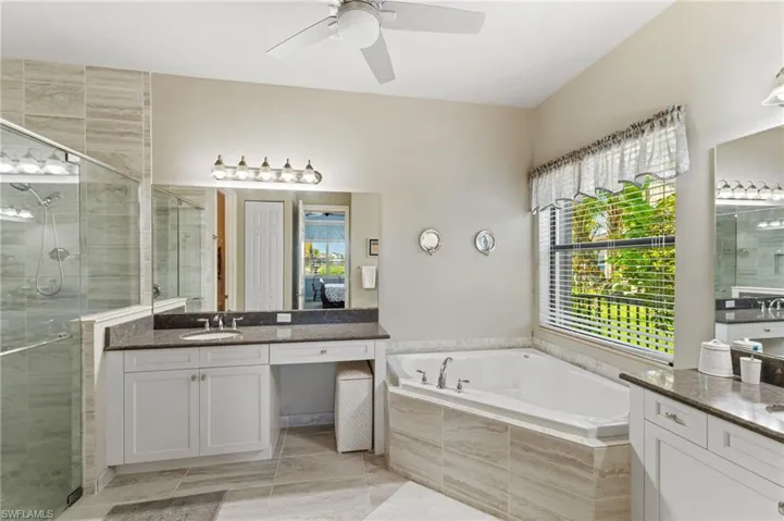 Primary bath features separate tub and shower and vanities