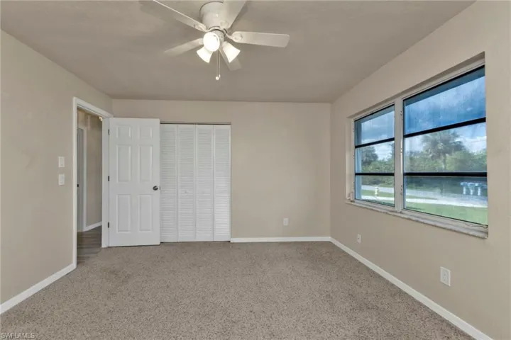 Unfurnished bedroom featuring carpet flooring, a closet, and ceiling fan