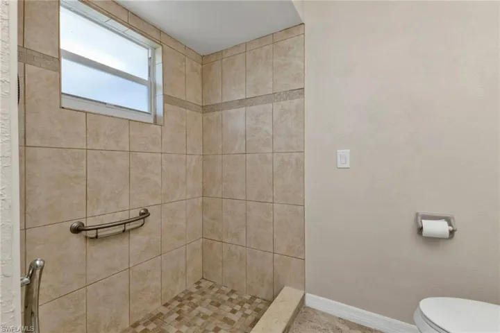 Bathroom with toilet and a tile shower