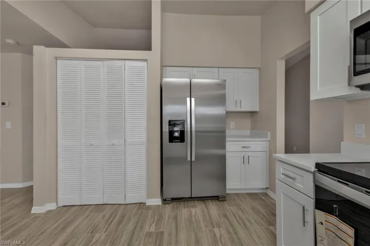 Kitchen featuring stainless steel appliances and white cabinetry