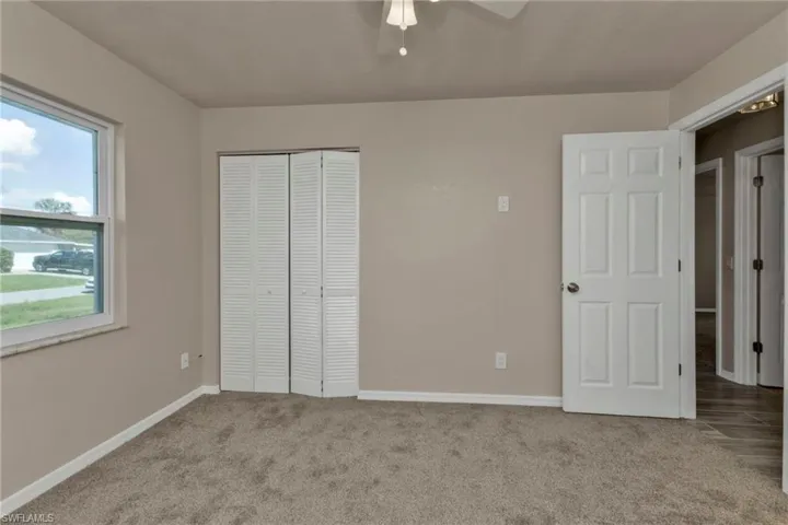 Unfurnished bedroom with a closet, ceiling fan, and light colored carpet
