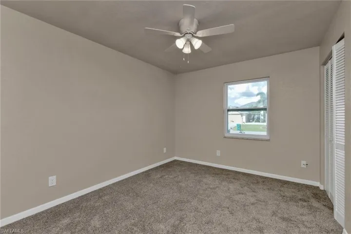 Unfurnished bedroom featuring carpet, ceiling fan, and a closet