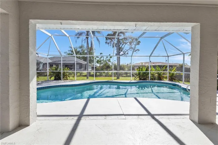 View of swimming pool with a patio and glass enclosure