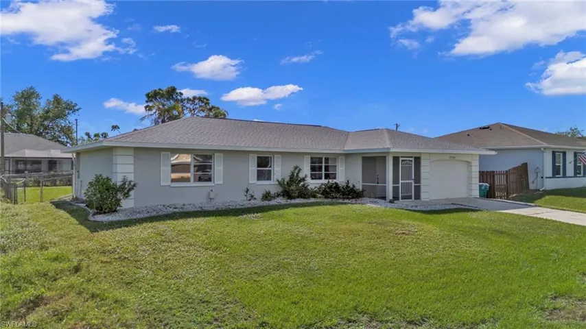Ranch-style house featuring a front lawn and a garage