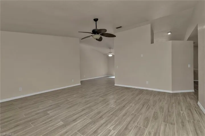 Unfurnished living room with ceiling fan and light wood-type flooring
