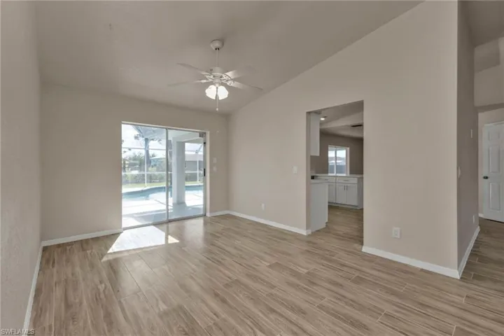 Spare room with a wealth of natural light, ceiling fan, light hardwood / wood-style flooring, and vaulted ceiling