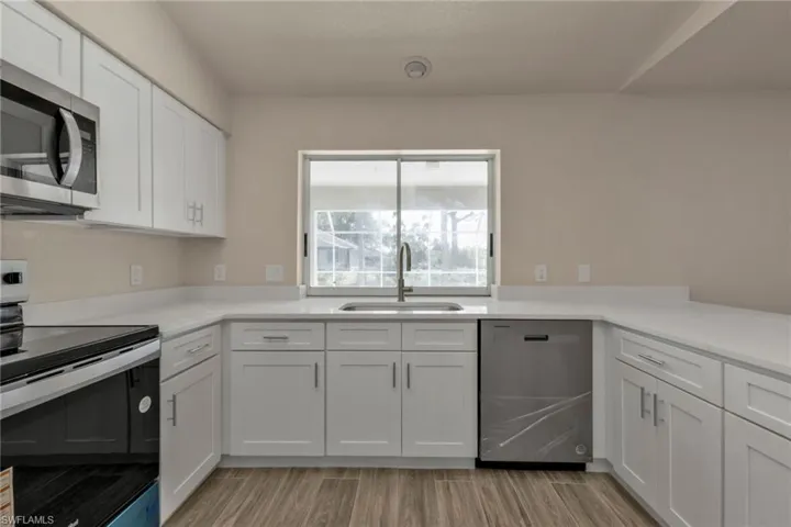 Kitchen featuring white cabinets, sink, and stainless steel appliances