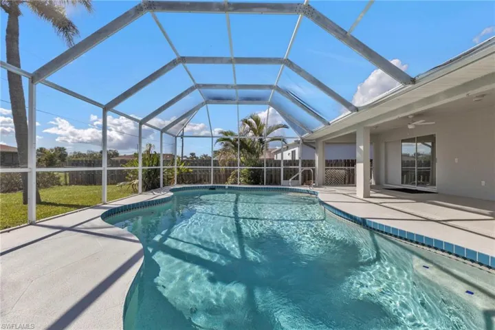 View of swimming pool with a patio, ceiling fan, and a lanai