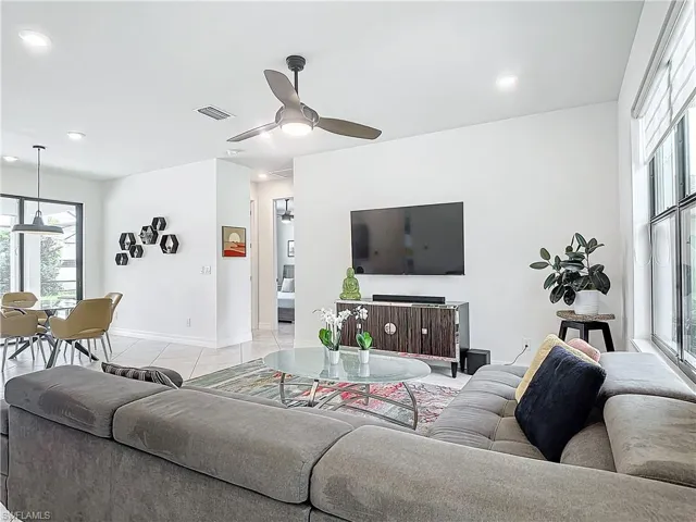 Living room with ceiling fan and light tile patterned floors