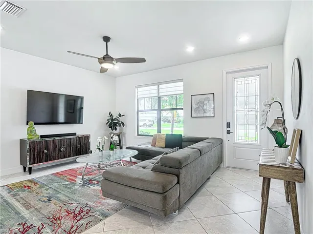 Tiled living room with ceiling fan and plenty of natural light