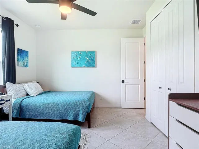 Bedroom featuring light tile patterned floors, a closet, and ceiling fan