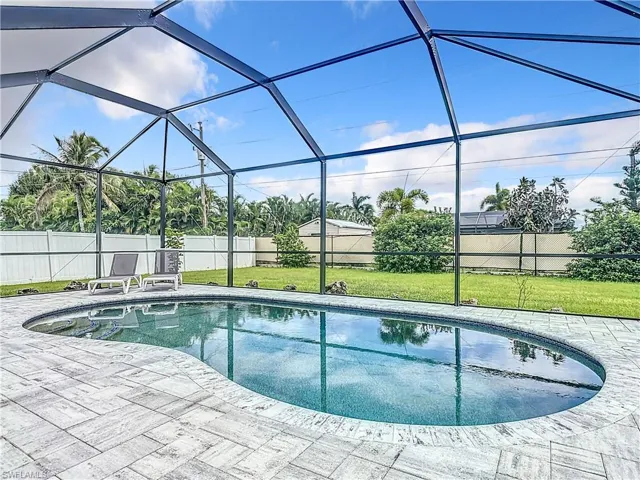View of pool featuring a lanai, a patio area, and a lawn