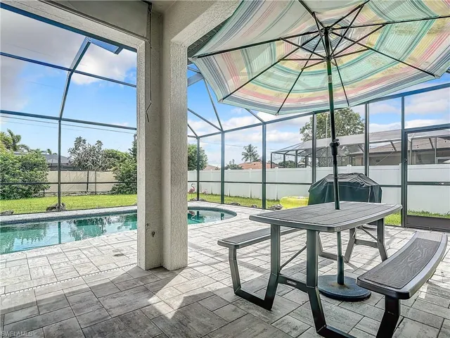 View of swimming pool with a patio, a lawn, and a lanai