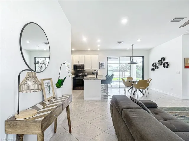 Living room featuring light tile patterned floors and a notable chandelier