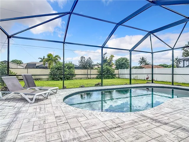 View of pool featuring a lanai, a lawn, and a patio