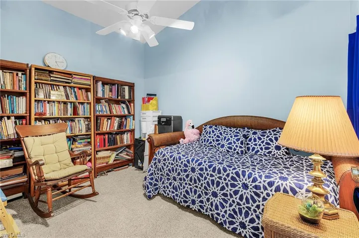 Bedroom with carpet floors, ceiling fan, and a high ceiling