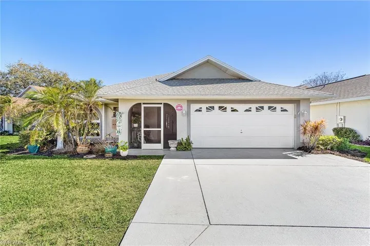 Single story home with a front lawn, concrete driveway, a garage, stucco siding, and a shingled roof