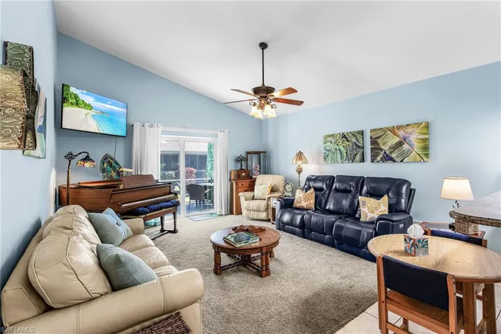 Carpeted living area with lofted ceiling and a ceiling fan