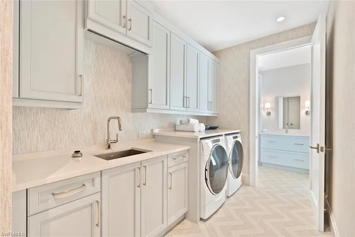Laundry room with cabinet space, separate washer and dryer, and recessed lighting