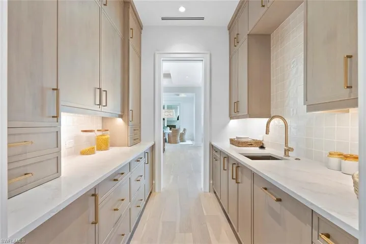Kitchen with light brown cabinetry, light stone countertops, and recessed lighting