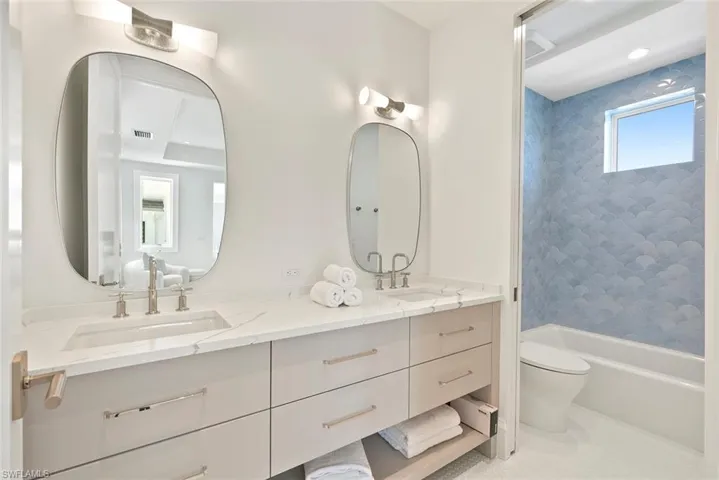 Bathroom with double vanity and shower / tub combination