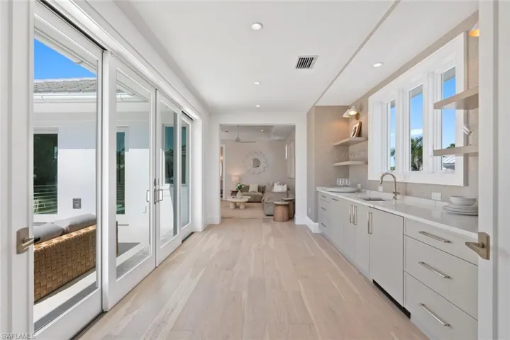 Kitchen featuring open shelves, light wood-style flooring, recessed lighting, light stone counters, and modern cabinets