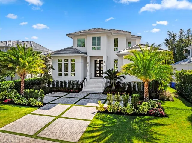 View of front of home featuring a front lawn, stucco siding, and french doors
