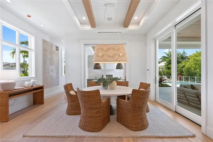 Dining room with light wood-type flooring, beam ceiling, and recessed lighting