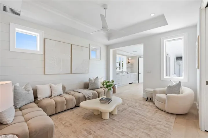 Living area featuring ceiling fan, crown molding, wood finished floors, and healthy amount of natural light