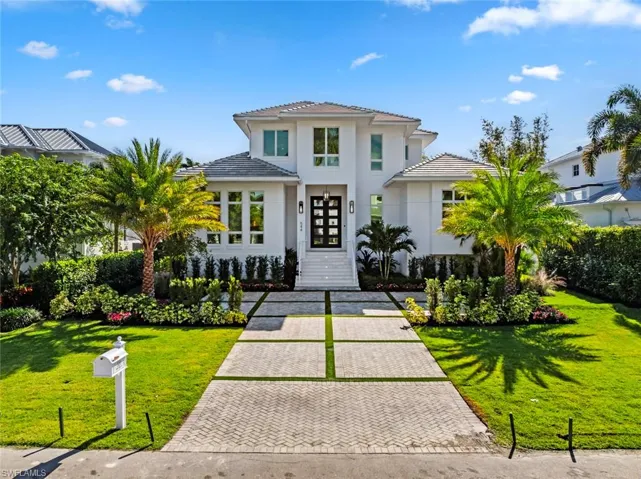 View of front facade with a front lawn and stucco siding