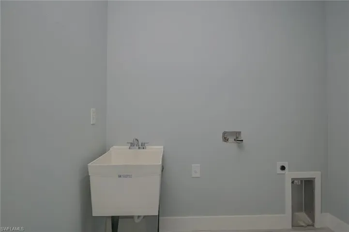 Washroom featuring hookup for a washing machine, hookup for an electric dryer, and sink