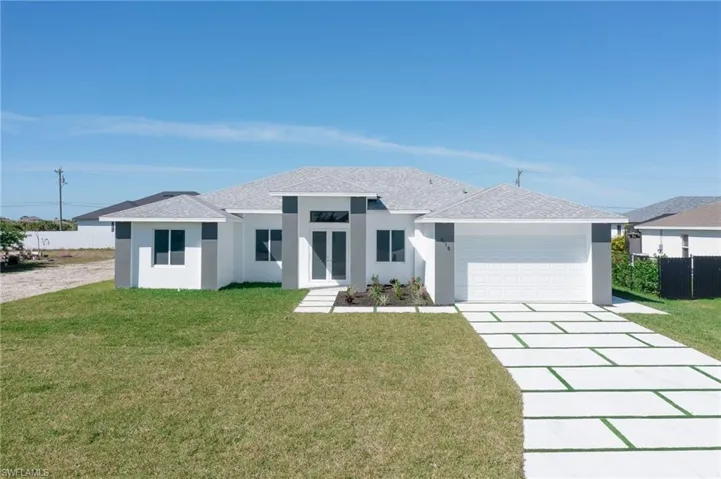 View of front facade with a garage and a front lawn