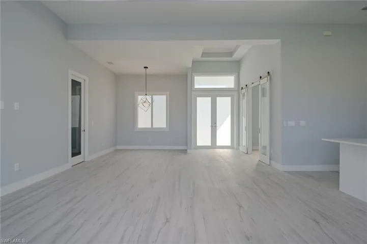 Unfurnished living room featuring a barn door and light wood-type flooring
