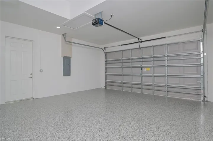 Garage with electric panel and a garage door opener
