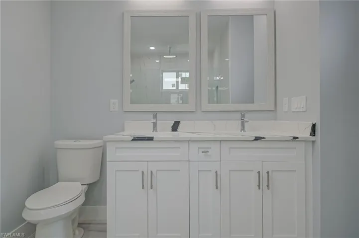 Bathroom with vanity, toilet, and an enclosed shower