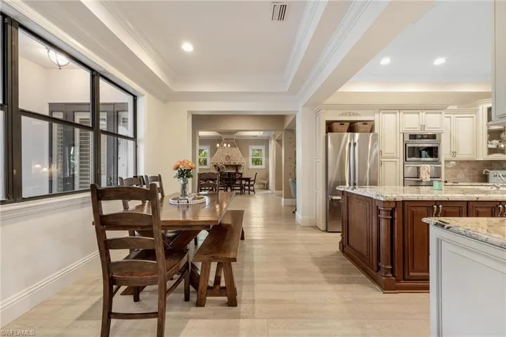 Dining room with light hardwood / wood-style floors and crown molding